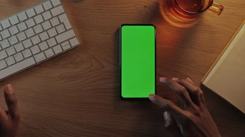 Man typing on keyboard and scrolling on green mobile scree Stock Footage 162841280