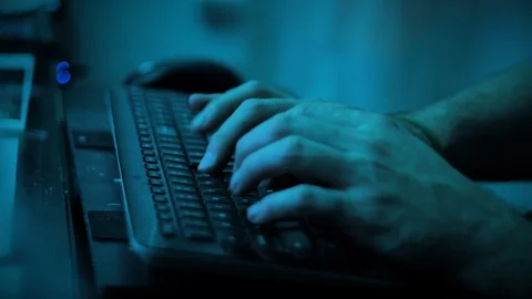 Man typing on keyboard in a blue room Vídeos de archivo 118976461