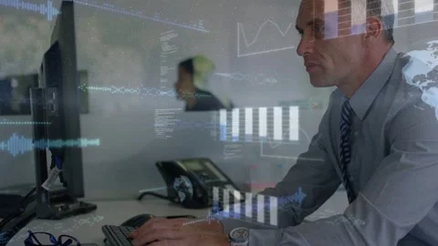 Man typing keyboard, camera pulling back as bar charts overlaying monitor for Video stock 333106011