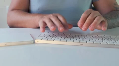 Man typing on keyboard in front view, hands pressing keys during computer work Stock Footage 333768714