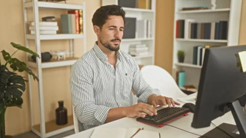Man typing on keyboard with hands visible at desk in a studio with computer.. Stock Footage 347693442