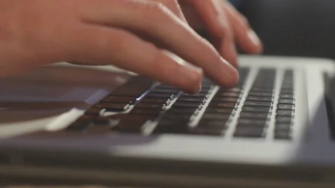 Man typing on the keyboard of his MacBook Stock-Footage 136310183