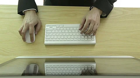 A man is typing on a keyboard with a mouse on the desk Stock Footage 313371484