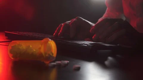 Man is typing on a keyboard. Pills in the foreground Stock Footage 118446853