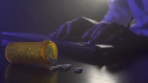 Man is typing on a keyboard. Pills in the foreground Stock Footage 119452648