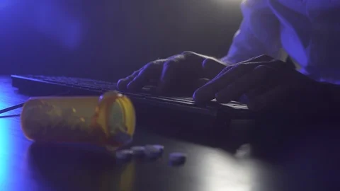 Man is typing on a keyboard. Pills in the foreground Stock Footage 119452717