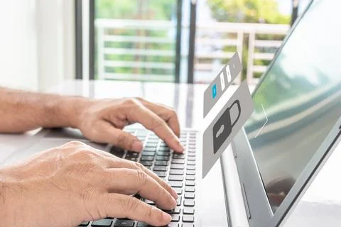 Man typing on keyboard to use computer network. Laptop screen showing login.. Stock Photos