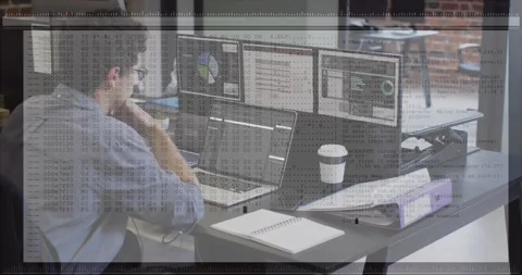 Man typing on laptop and checking monitors with charts, causing hex code overlay Stock Footage 331286710