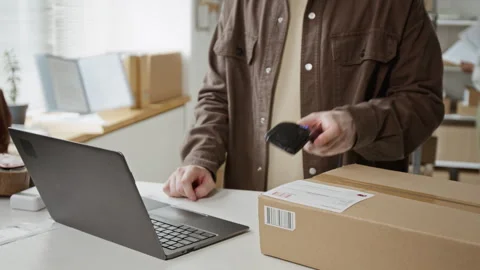 Man Typing on Laptop and Scanning Barcode on Cardboard Box Stock Footage 342596883