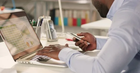 Man typing on laptop and using phone in a startup office - track left. Stock Footage 92166365
