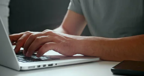 Man typing on laptop in bright workspace Stock Footage 318799704