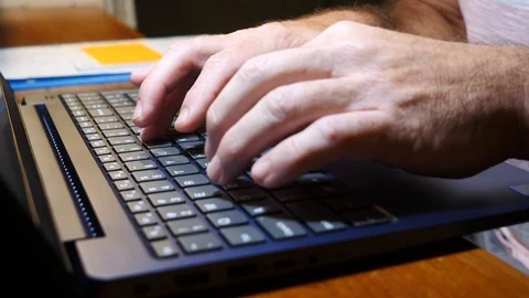 Man typing on laptop computer at a desk showing hands, 4k, 60fps. Stock Footage 116336145