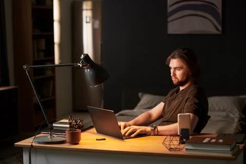 Man Typing on Laptop during Remote Work Late at Night Stock Photos
