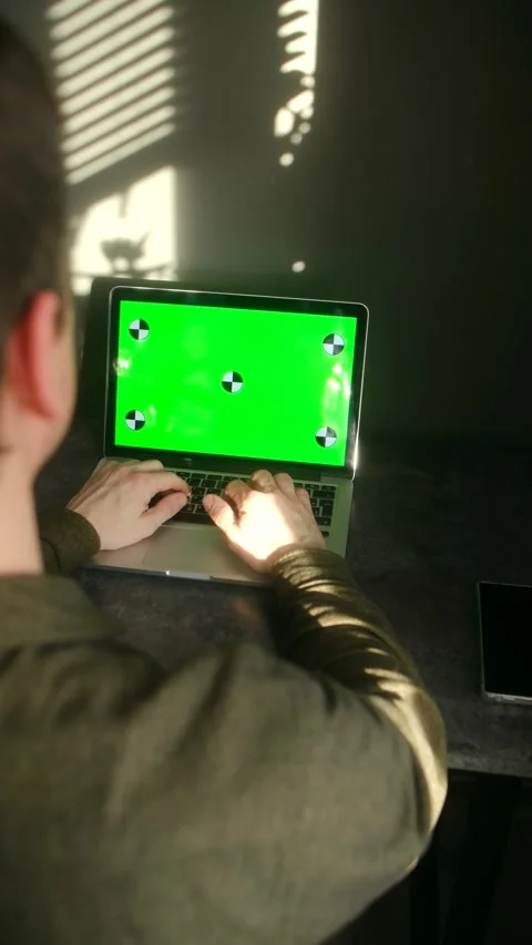 Man typing on laptop with green screen working from home Stock Footage 337831246