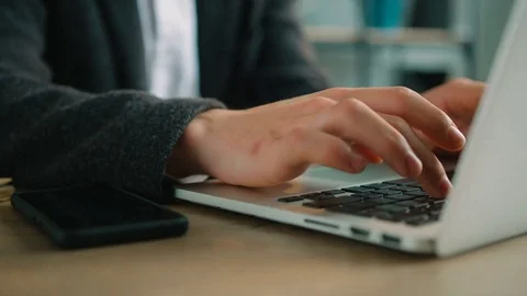 Man typing on laptop keyboard in the office. Close up man hands writing on Stock Footage 75763649