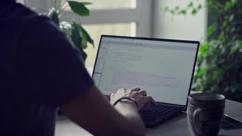 Man typing on laptop keyboard working at home in front of a window Video stock 272197292