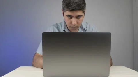 A man is typing on a laptop looking for something on the Internet Stock Footage 169442802