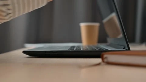 A man typing on a laptop at a table, close-up of a woman's hands closing the Stock Footage 339005570
