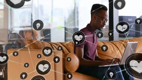 Man typing on laptop in tech office visualizing health idea pin icons expanding Stock Footage 330143199