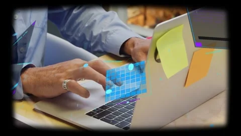 Man typing on laptop in tech workspace, hands hovering and activating blue UI Stock Footage 334039657