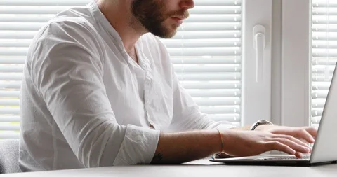 Man typing at laptop then looking at camera Stock Footage 111037294