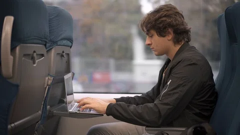 Man typing on laptop in the train Stock Footage 98250076