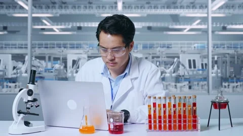 Man Typing On A Laptop While Working With Microscope And Test Tube In The Lab Video stock 269819249