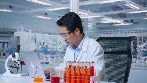 Man Typing On A Laptop While Working With Microscope And Test Tube In The Lab Video stock 269820686