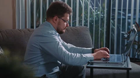 Man typing on laptop working from home near window Stock Footage 340206198