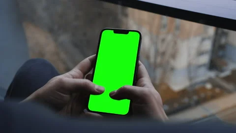 A man typing a message on the chroma key screen of a smartphone. Video stock 234510255