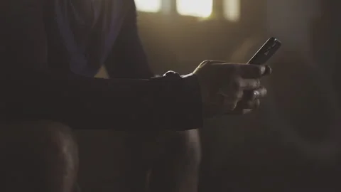 Man typing message on phone at gym Stock Footage 236192026