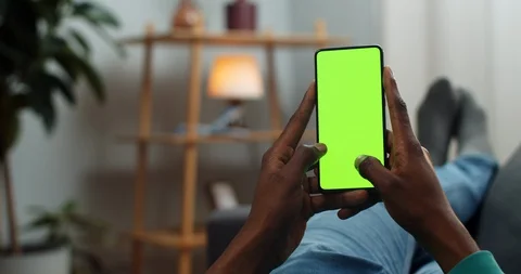 Man typing message on smartphone mock up screen while spending time at home Stock Footage 129820844