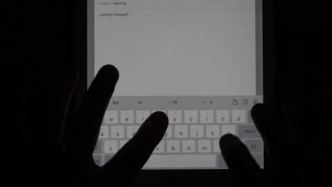 A man typing a message on a tablet computer in the dark Stock Footage 221426717