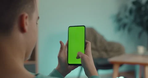 Man typing messages on mobile with green mock up screen Stock-Footage 163704282