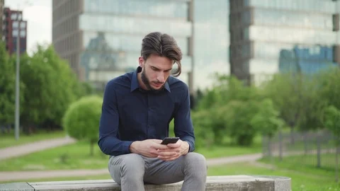 Man typing messages sitting on bench Video stock 113698510