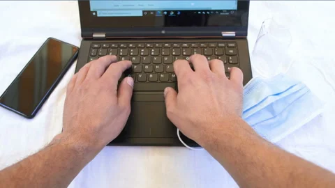 Man Typing On pc Keyboard while working on web business in coronavirus disease Stock Footage 136036335