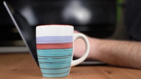 Man typing on pc while drinking a hot drink Stock Footage 124140497