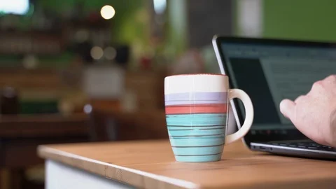 Man typing on pc while drinking a hot drink Stock Footage 124141491