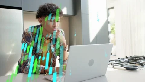 Man typing on silver laptop at kitchen counter, causing descending candlesticks Stock Footage 333155545