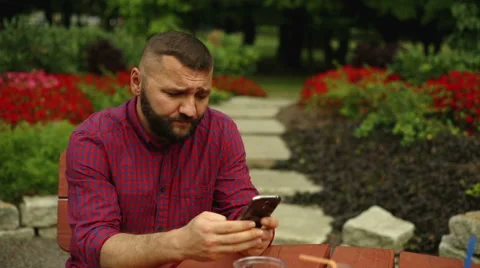 Man is typing sms in the park Stock Footage 65816291
