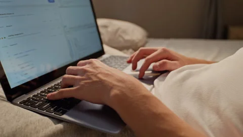 Man Typing Software Code on Laptop during Remote Work in Bed 库存影片 346608083