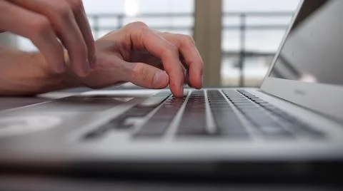 A man is typing something on a laptop Foto stock