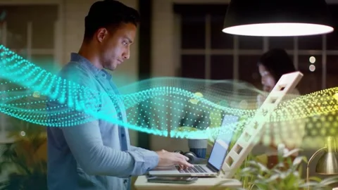 Man typing at standup desk for work in tech office, dotted waveform sweeping Stock Footage 334694093