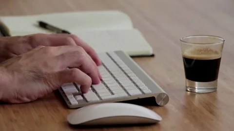 Man Typing On A Tech Keyboard, Taking Notes and Coffee Footage 4K Stock Footage 253842888