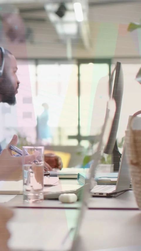 Man typing in tech office, pointing while explaining analytics as neon charts Stock Footage 333109803