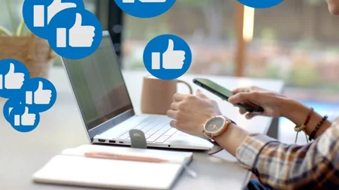 Man typing then reaching for smartphone, checking social feed, blue thumbs up Stock Footage 335283047