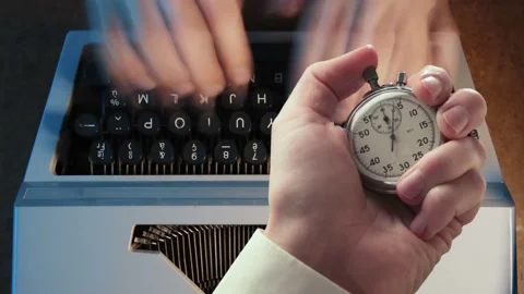 A man typing on a typewriter and stopwatch in a hand Video stock 235155123