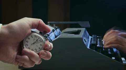 A man typing on a typewriter and stopwatch in a hand Stock-Footage 235155732