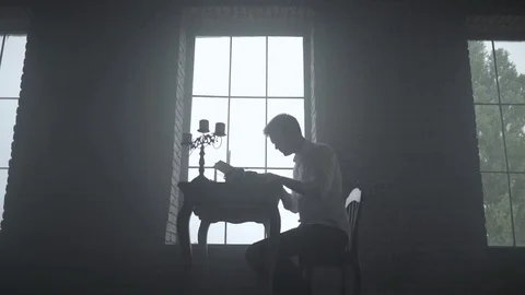 Man typing on a typewriter in a dark room Stock Footage 72634591