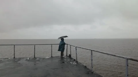 Man with umbrella on the beach under the rain Stock-Footage 65025457